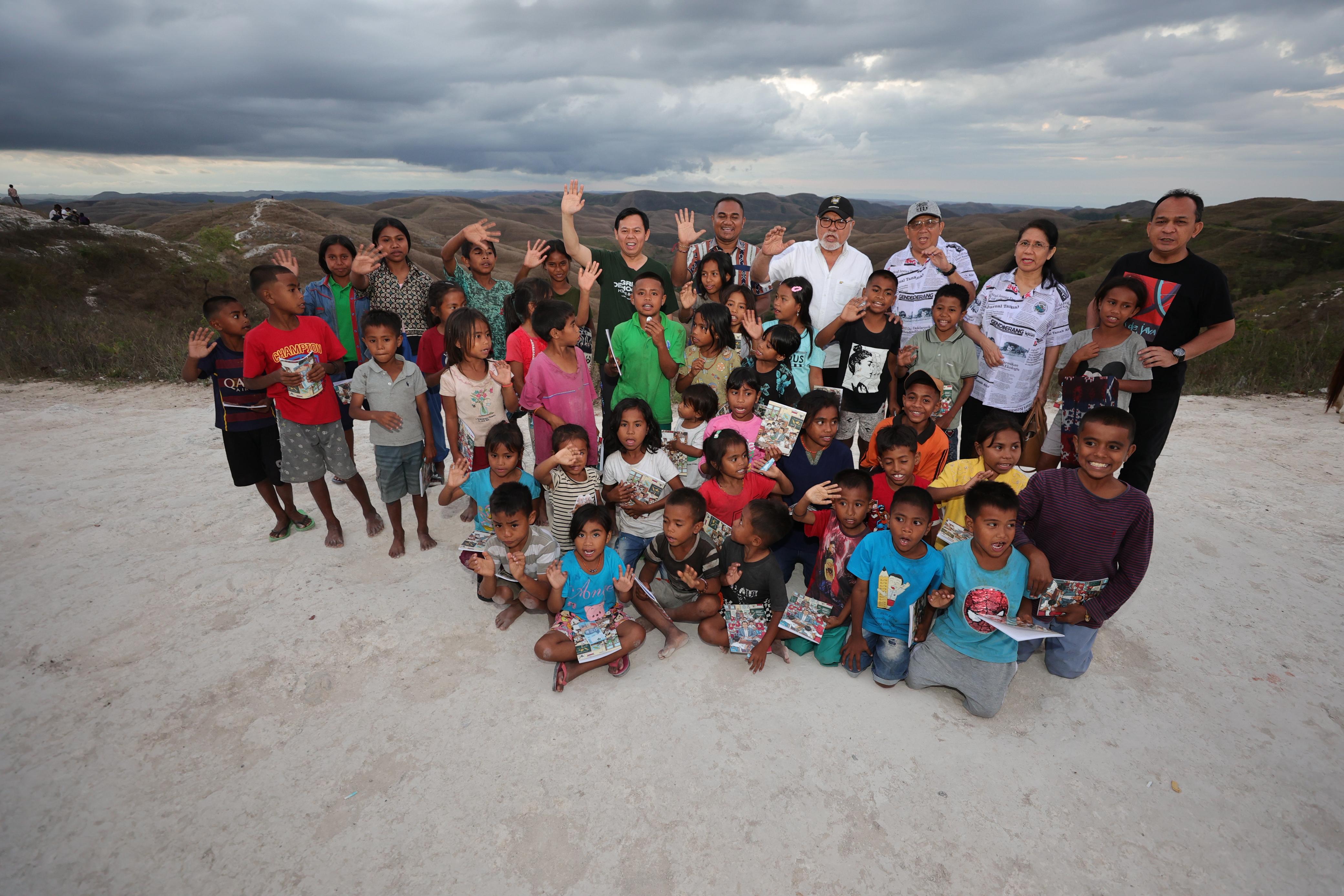 Kegiatan volunteer bersama anak-anak di lokasi terbuka dengan latar belakang perbukitan